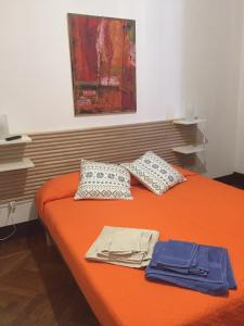 ein orangenes Bett mit zwei Kissen darüber in der Unterkunft B & B 21 Bologna in Bologna