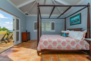 a bedroom with a canopy bed and a patio at Seaview Palms Villa - St Croix USVI in Christiansted