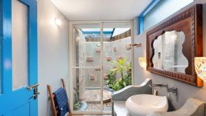 a bathroom with a shower and a white sink at Aphrodite Homestays Coorg by The Almanac in Napoklu +32 photos