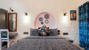 a bedroom with a bed and a mirror at Aphrodite Homestays Coorg by The Almanac in Napoklu