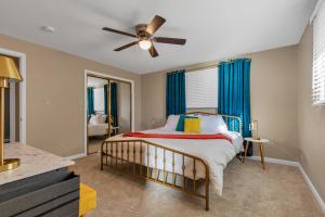 um quarto com uma cama e uma ventoinha de tecto em ᨒFIREHAUSᨒHotTubᨒCinemaᨒBBQᨒBadmintonᨒGames em Arvada