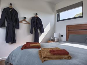 1 dormitorio con 1 cama con abrigos en la pared en Meeniyan360 en Meeniyan