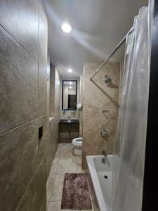 ein Badezimmer mit einer Dusche, einer Badewanne und einem WC in der Unterkunft Hotel-Studio @ The Mansfield Midtown in New York