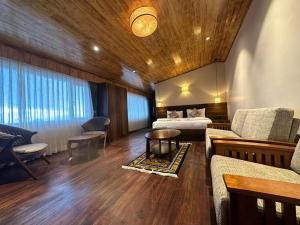 Cette chambre comprend un lit, un canapé et une table. dans l'établissement Gakhil Boutique Hotel, à Darjeeling