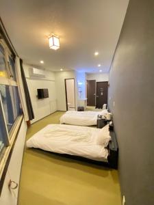 a hotel room with two beds and a hallway at ロマンスホテル（Romance Hotel） in Nakamachi