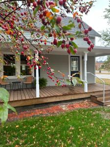 a house with a wooden deck with a table on it at Crabapple Cottage in Hesston