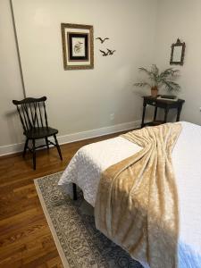 a bedroom with a bed and a chair and a table at Crabapple Cottage in Hesston