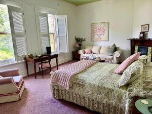 1 dormitorio con cama, sofá y mesa en Penghana Bed and Breakfast, en Queenstown