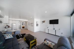 sala de estar con sofá y TV en Blackrock Apartments Queenstown en Queenstown