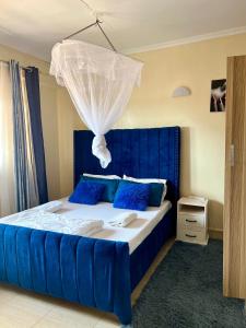 a bedroom with a blue bed with a blue headboard at Exquisite Modern suite 1bedroom in Busia