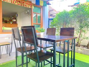 a wooden table and chairs on a patio at Chinda Boutique Hotel in Chiang Mai