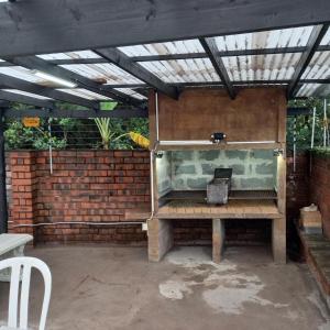 a patio with a wooden bench and a brick wall at Rilli's Inn Studio in Mtunzini