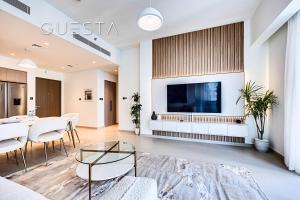 a living room with a large tv and a table at Act One Act Two by Emaar, Downtown Dubai in Dubai