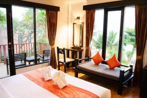a hotel room with two beds and a balcony at Merit Resort Samui in Lamai