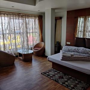 een slaapkamer met een bed en een woonkamer bij Hotel Mountain View in Kalimpong