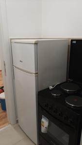 a white refrigerator and a stove in a kitchen at Oaza Apartment Mirijevo, Free Garage Parking in Belgrade