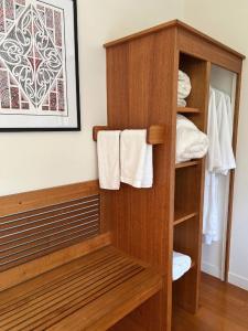 uma casa de banho com um armário de madeira e toalhas em Forest Hideaway ~ Rustic em Coromandel Town