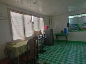 a room with a table and a kitchen with a window at Ustaris Homestay in Itaytay