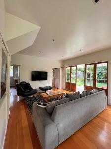 a living room with a couch and a table at Forest Hideaway ~ Rustic in Coromandel Town