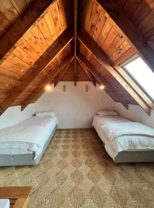 two beds in a room with an attic at Forest Hideaway ~ Rustic in Coromandel Town