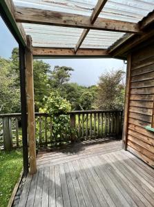 a wooden deck with awning on a house at Forest Hideaway ~ Rustic in Coromandel Town