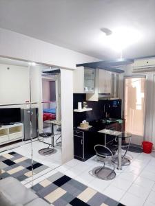 a kitchen with three chairs and a table in it at Apartemen Kalibata City By Diamond Property in Jakarta