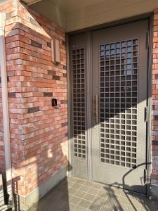 drzwi wejściowe ceglanego domu z ceglaną ścianą w obiekcie 晋～SHIN～各務原 w mieście Kakamigahara