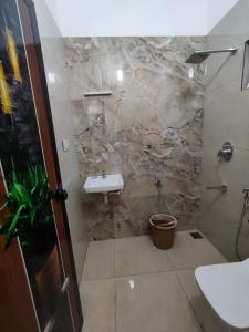 uma casa de banho com um lavatório e uma parede de pedra em Alam Home Stay em Cochin