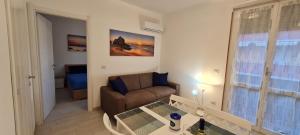 sala de estar con sofá y mesa en Aedes Residenza Lido - 80 mt dalla spiaggia - self check-in en Alghero