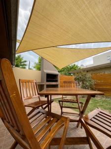 un patio con una mesa de madera y 2 sillas en Departamentos Lidia en Mar del Plata