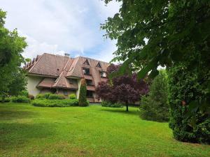 una casa grande con un patio verde delante de ella en Szoba kilátással apartman, en Gárdony