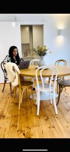 a woman sitting at a table with a laptop at Owl+Oak in Castlemaine