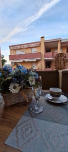 una mesa con una copa de vino encima de una mesa en Aedes Residenza Lido - 80 mt dalla spiaggia - self check-in en Alghero