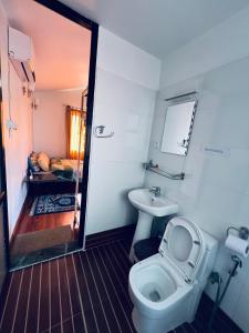 a bathroom with a toilet and a sink at Avocado Cottages in Khadkagaon