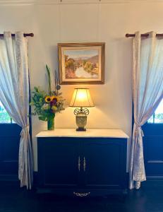 a table with a lamp and a vase of flowers at The Boston Ivy 1880 - The Residence in Mittagong