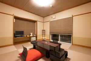 un soggiorno con tavolo da ping pong e televisione di Rurika a Izu