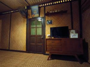 una stanza con una porta e una televisione su un comò di Mon Saeng Jun Homestay a Ban Na Meng (1)