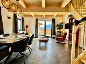 uma sala de jantar e sala de estar com mesa e cadeiras em Chalet near Nassfeld ski resort in Carinthia em Hermagor