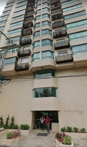 twee mensen die buiten een hoog gebouw staan bij Apartamento Beira mar Capão da Canoa in Capão da Canoa