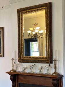 a mirror on a wall above a table with candles at The Boston Ivy 1880 - The Residence in Mittagong