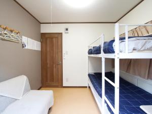 a room with two bunk beds and a door at 和貴ビル in Tokyo