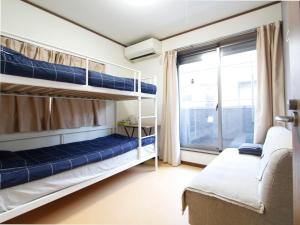 a bedroom with two bunk beds and a window at 和貴ビル in Tokyo