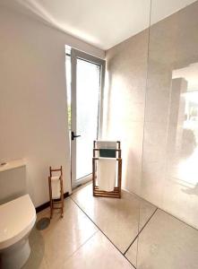 a bathroom with a toilet and a glass door at Meco Beach Villa with Private Pool in Sesimbra
