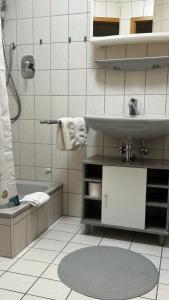 a bathroom with a sink and a shower and a tub at Smart Stay Apartment in Balingen in Balingen +8 photos
