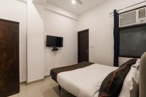 a bedroom with a bed and a flat screen tv at Insight Inn Near Gomti Riverfront Park in Vibhuti Khand