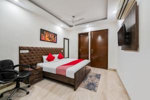 a bedroom with a bed and a desk and a chair at OYO 72284 Premium Rooms Chhatarpur in New Delhi