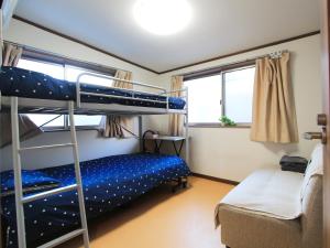 1 dormitorio con 2 literas y sofá en 和貴ビル, en Tokio