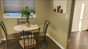 a dining room table with chairs and a potted plant at Like Home in Regina