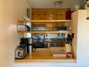 a small kitchen with wooden shelves and a stove at Flims Chalet in Flims