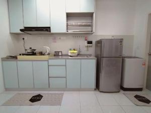 a kitchen with white cabinets and a stainless steel refrigerator at Camellia Residence ForestView 2BR 4Paxs near Seri Austin Mount Austin Johor Bahru in Johor Bahru